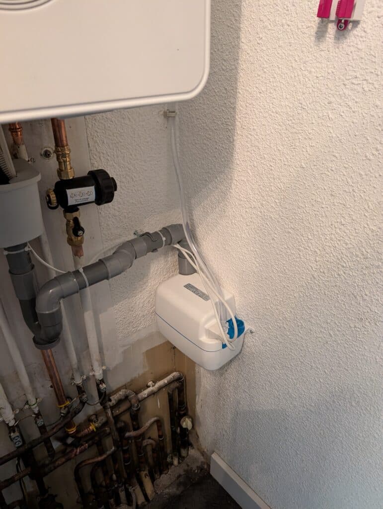 Installation d'une chaudière : chauffe-eau blanc équipé de tuyaux et de vannes.