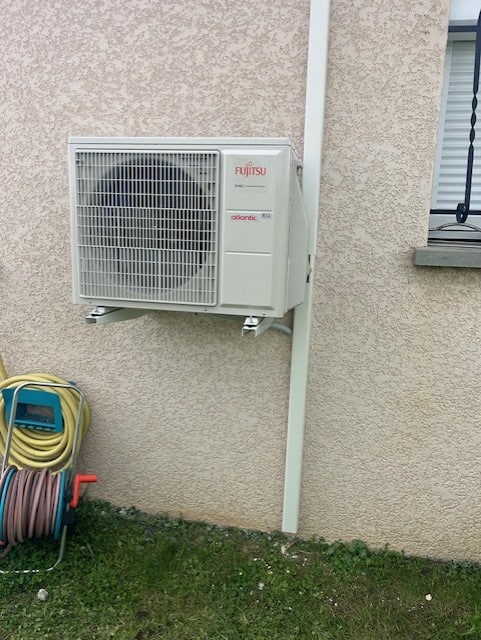 installation-pompe-a-chaleur-mur Un climatiseur blanc installé sur un mur, illustrant l'efficacité d'une installation de pompe à chaleur.